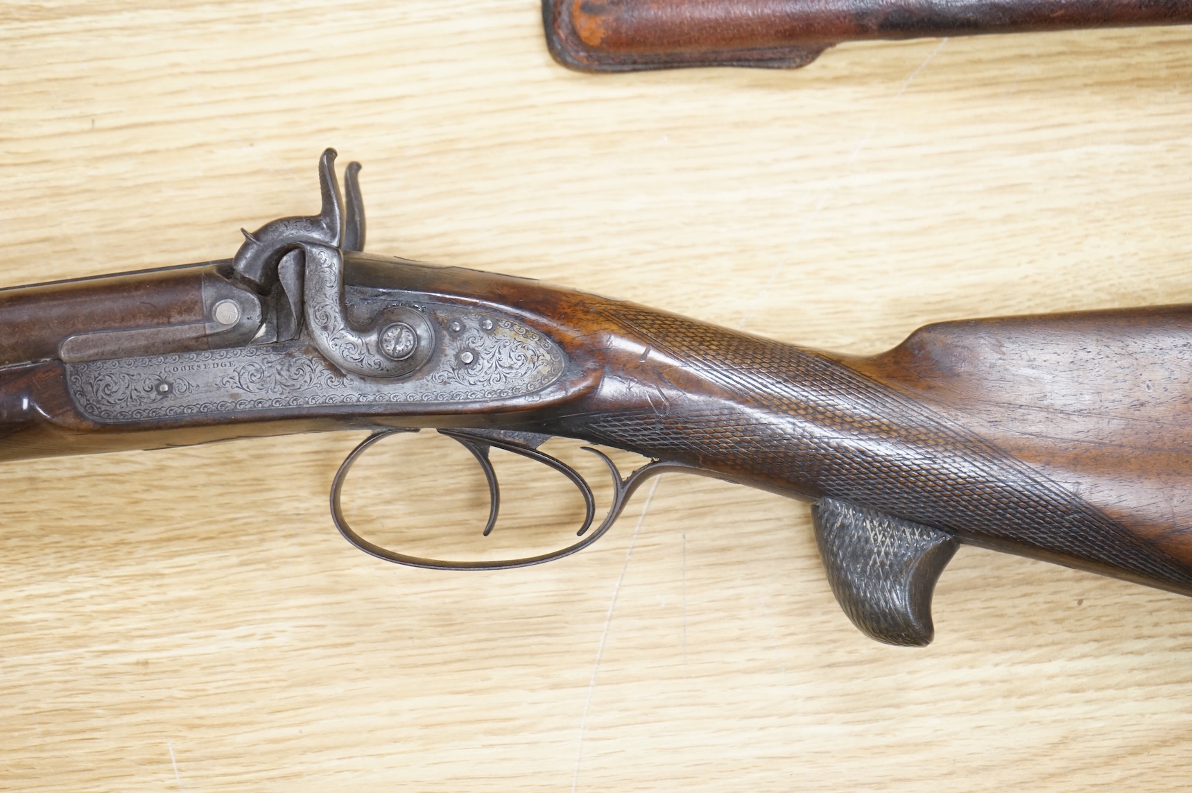 A double barrel 12 bore percussion sporting gun, signed Cocksedge, Hadleigh, with engraved locks and iron furniture, half stocked chequered grip with finger support in wood above guard